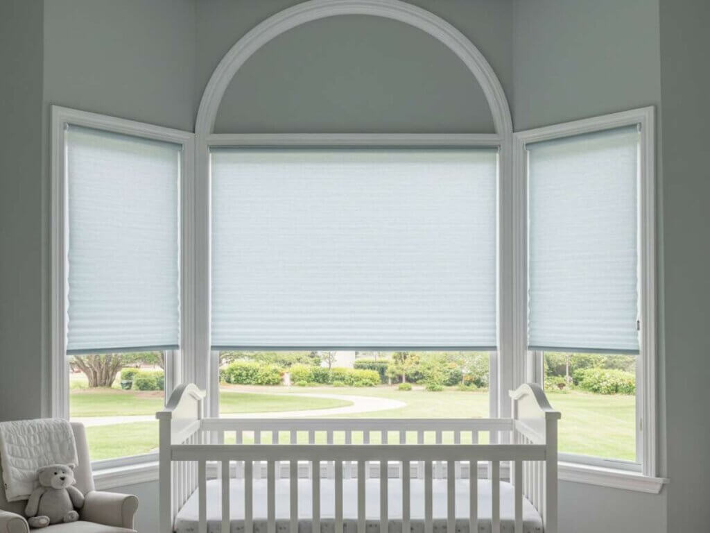 There are many practical considerations when choosing nursery window treatments including choosing cordless for safety, blackout options, using easy to clean materials, light control and privacy, sound and energy, and the room's style.