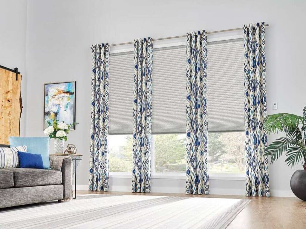 Combining blinds or shades with drapes allows homeowners to achieve a layered look that’s as functional as it is stylish.