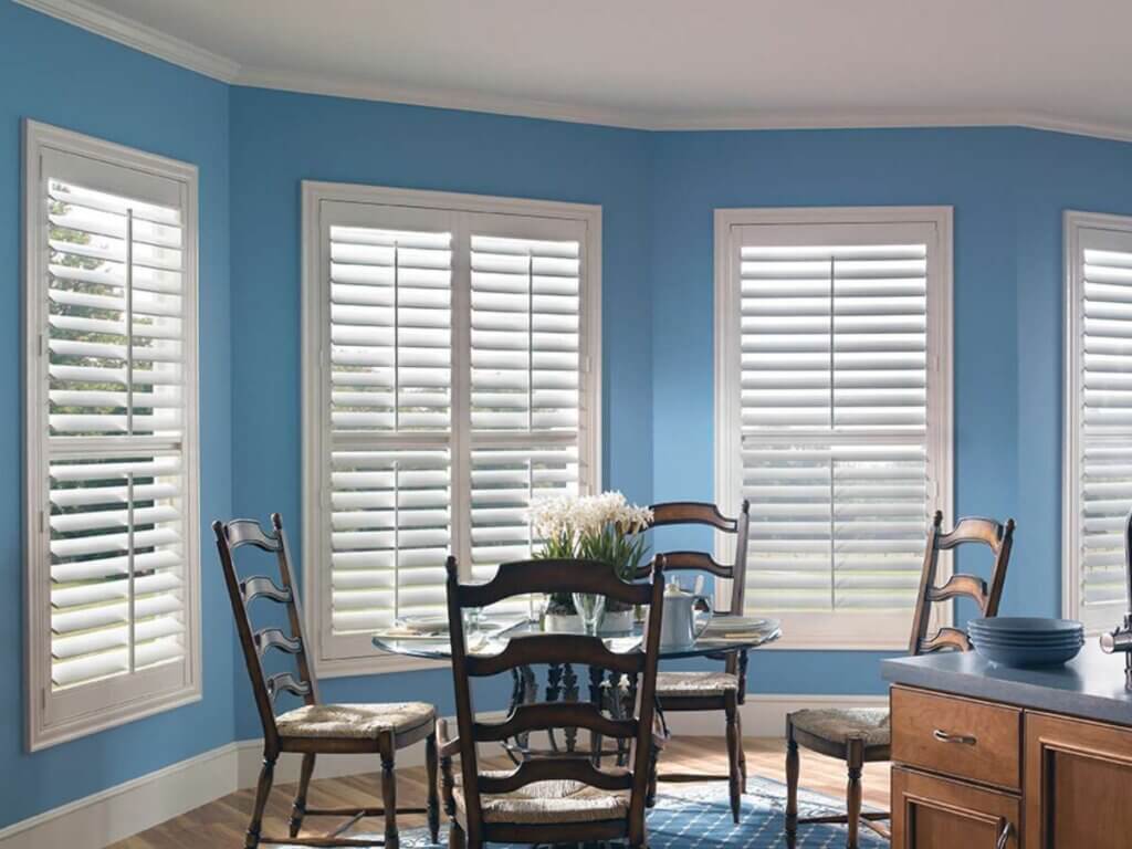 This is a photo of a white plantation shutters in a dining area