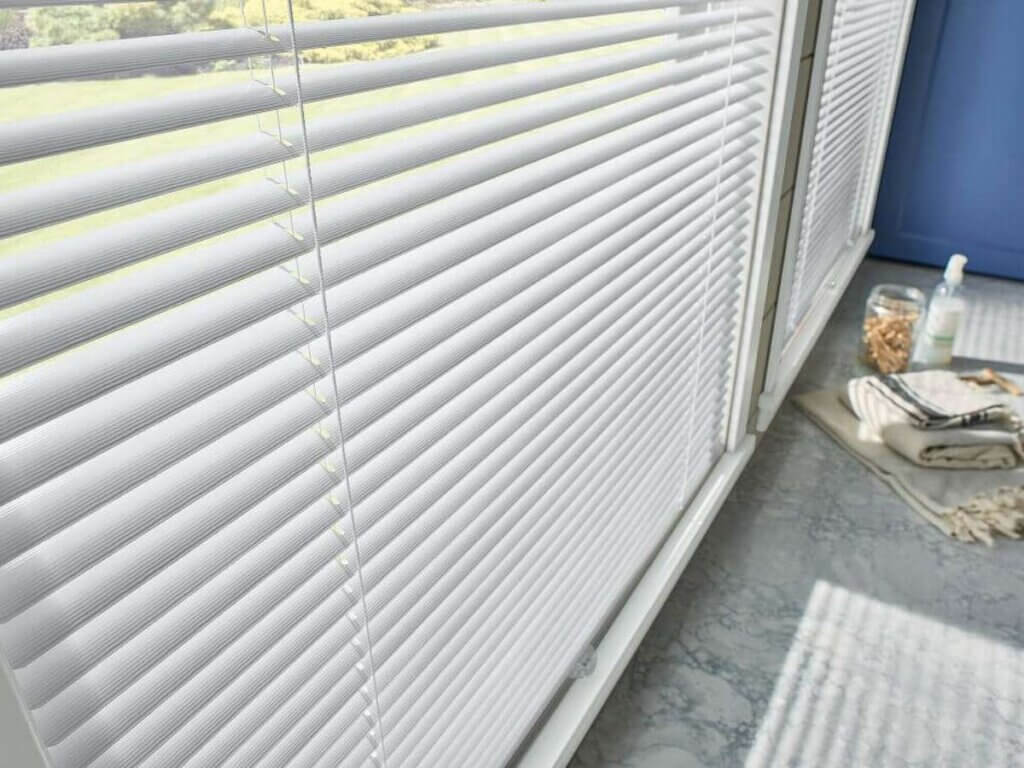 This is a close up shot of an aluminum blinds in a kitchen