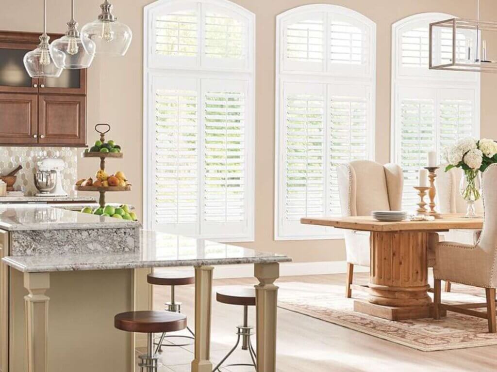 This is a white composite shutter in a dining area